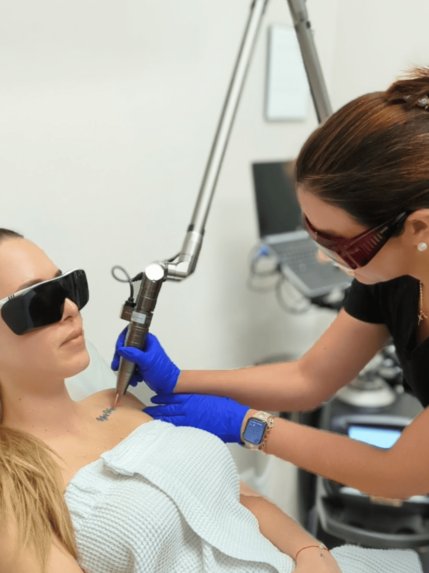 Specialist Wearing Safety Glasses Applies Best Laser Tattoo Removal On Blond Woman Wearing Safety Glasses And A White Dress