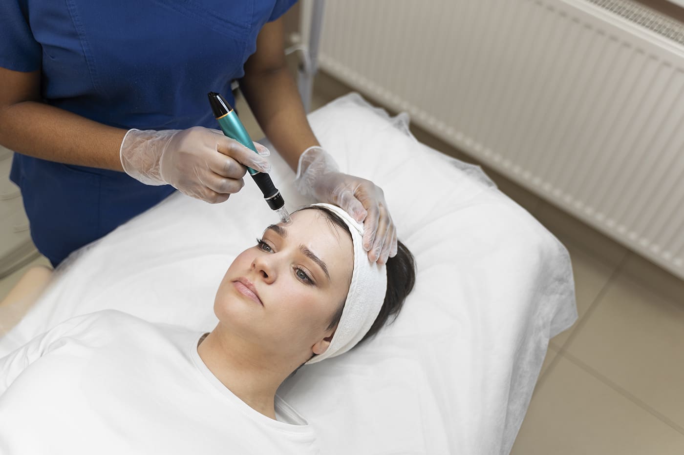 Woman wearing spa headband receiving morpheus8 microneedling facial treatment for facial rejuvenation