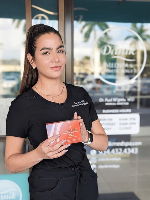 Specialist holding Kybella product box in front of Danik MedSpa.