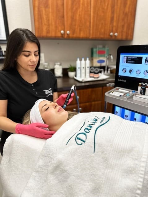 Specialist performing Hydrafacial treatment on a client at Danik MedSpa.